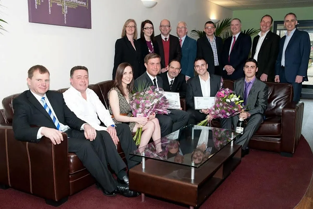 Award winners and judges with certificates and flowers at the ceremony