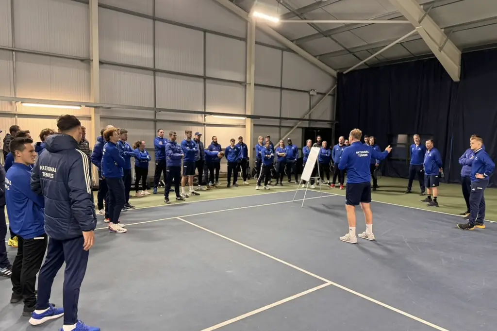Coaches gathered on an indoor court for a briefing