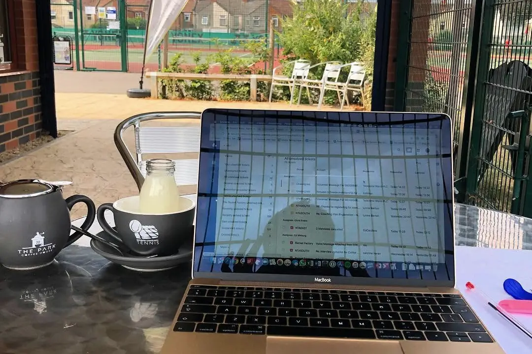 Coffee and a laptop at the café, overlooking the courts