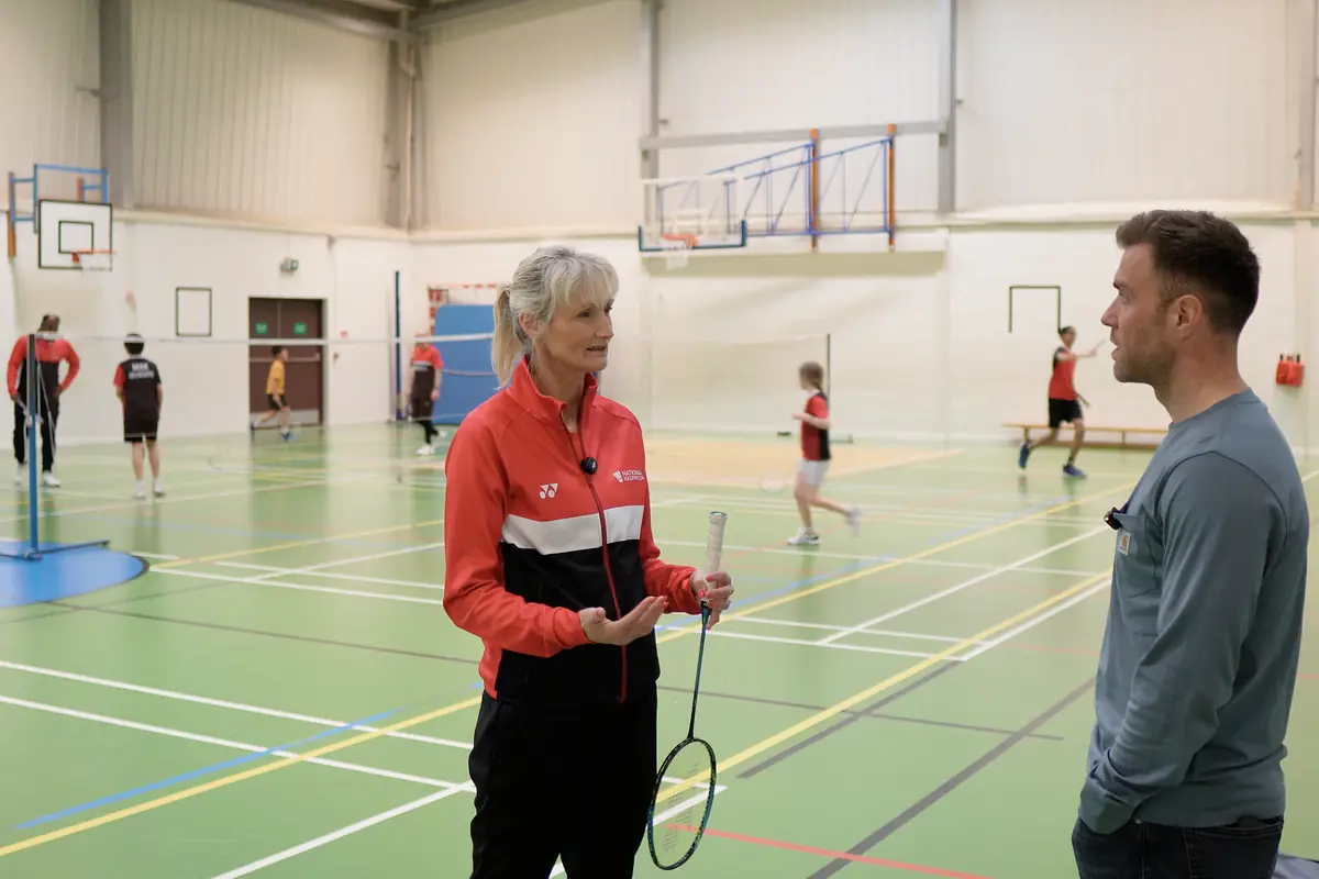 Ed and Julie Bradbury talking courtside during a junior session