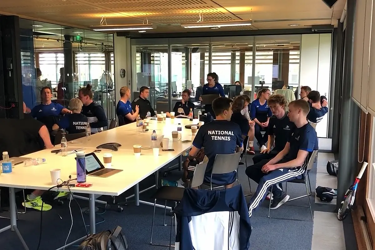 National Tennis coaches around a table at a team meeting