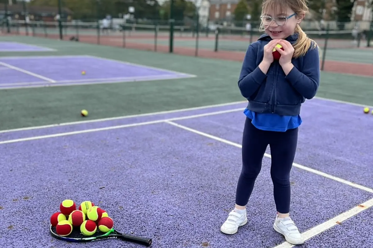Ed’s daughter holding a tennis ball on the Swindon courts