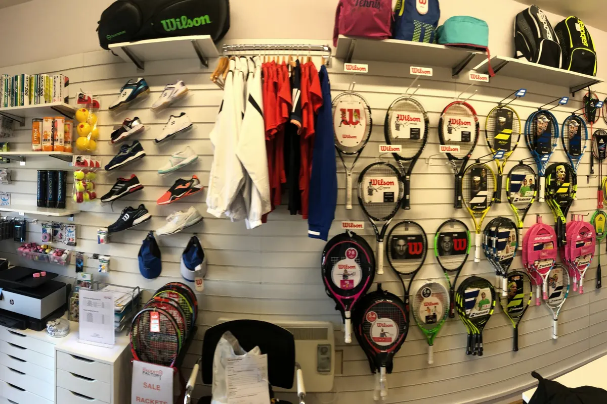 A full wall of rackets, shoes and clothing